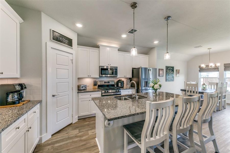 Kitchen featuring white cabinets, light hardwood / wood-style floors, appliances with stainless steel finishes, and sink