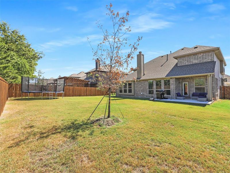 View of yard with a trampoline and a patio