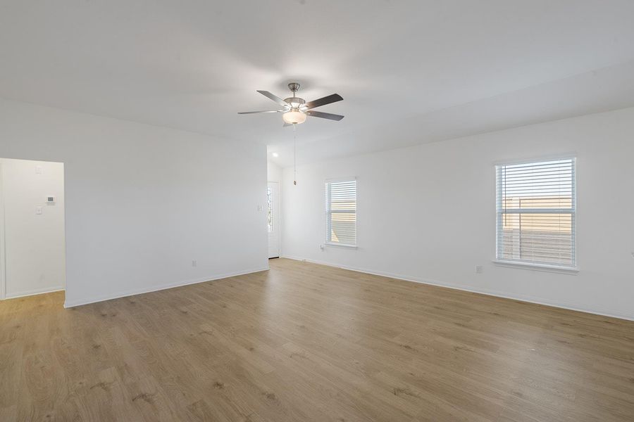 A spacious living area with light wood flooring and ample natural illumination. A spacious living area with light wood flooring and ample natural illumination.