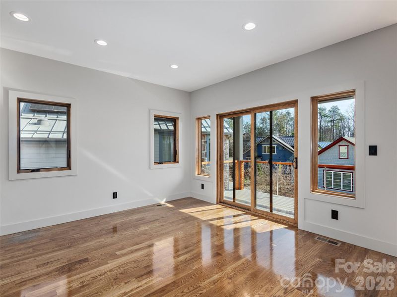 Dining area with oak hardwood floors and large sliding glass doors opening to the covered porch, creating an easy indoor-outdoor flow.