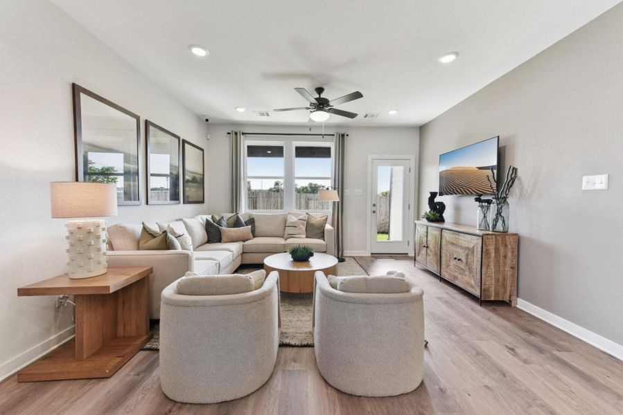 Living area featuring light wood-style floors, a ceiling fan, and recessed lighting