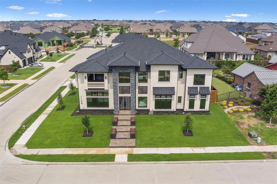 View of front of home with a front lawn and a balcony