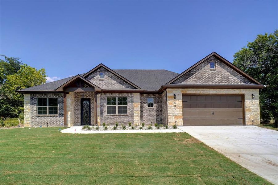 View of front of house with a garage and a front yard