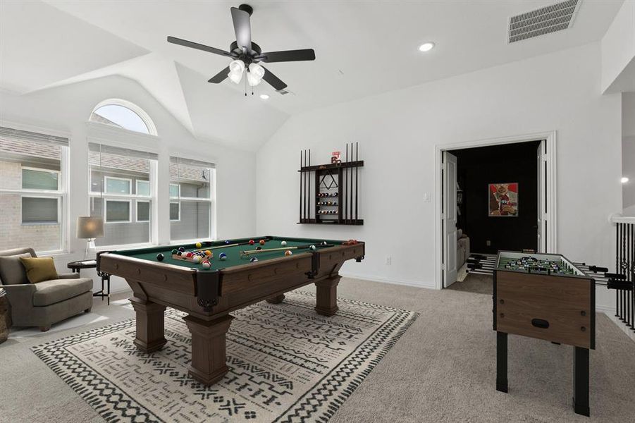 Playroom with vaulted ceiling, pool table, carpet flooring, a ceiling fan, and recessed lighting Playroom with vaulted ceiling, pool table, carpet flooring, a ceiling fan, and recessed lighting