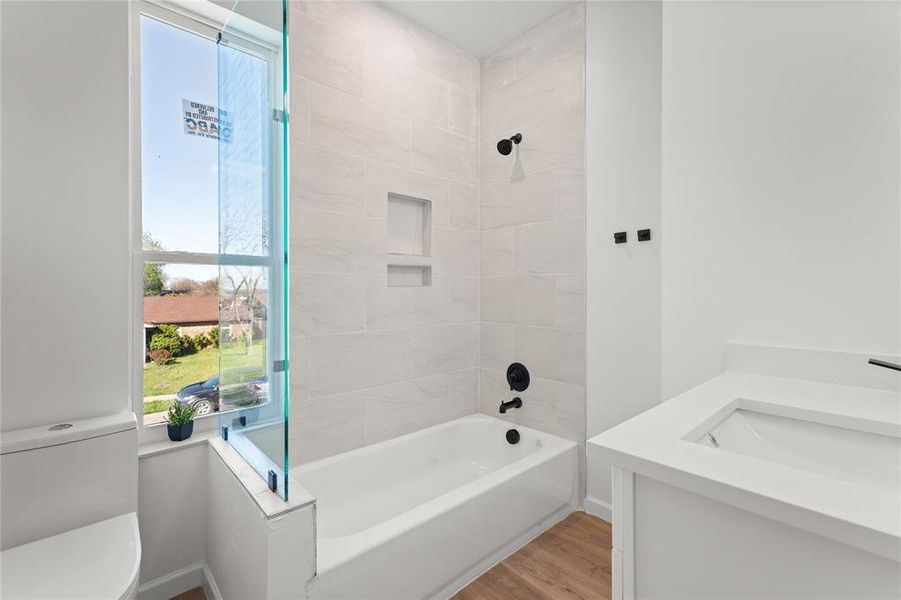Full bath featuring vanity, light wood finished floors, and tub / shower combination