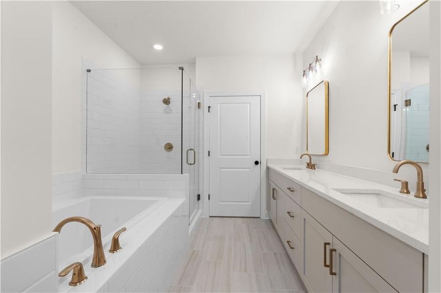 Bathroom with double vanity, a jetted tub, a stall shower, and recessed lighting