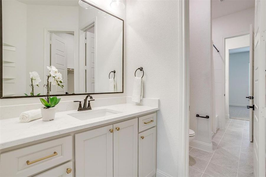 Bathroom featuring tile patterned floors, toilet, and vanity