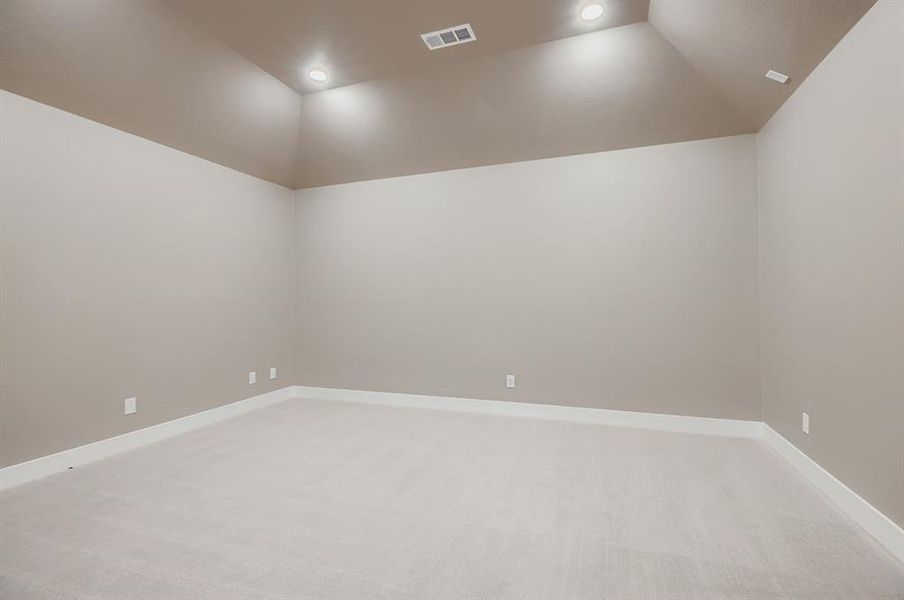 Spare room featuring lofted ceiling, light carpet, and recessed lighting