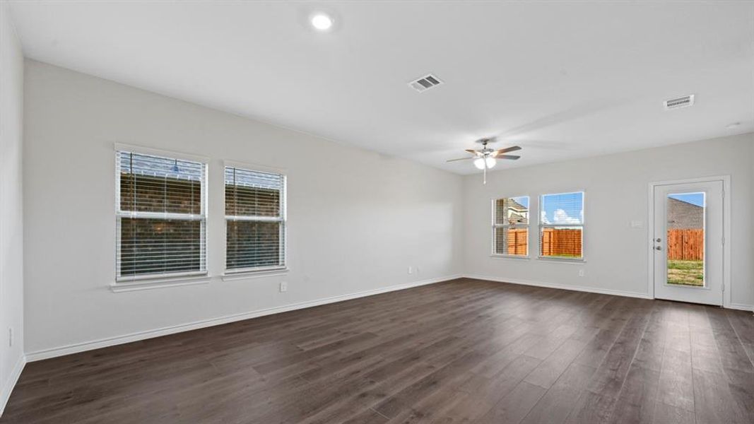 Empty room with dark wood-style flooring and a ceiling fan Empty room with dark wood-style flooring and a ceiling fan