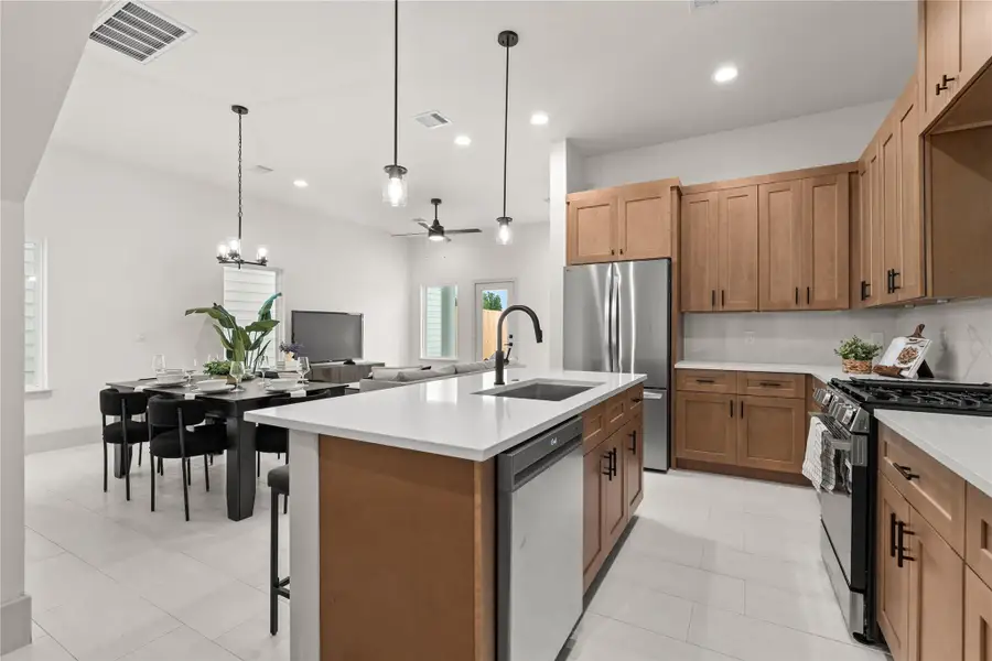 From the kitchen, every space connects — dining, living, and the backyard beyond From the kitchen, every space connects — dining, living, and the backyard beyond