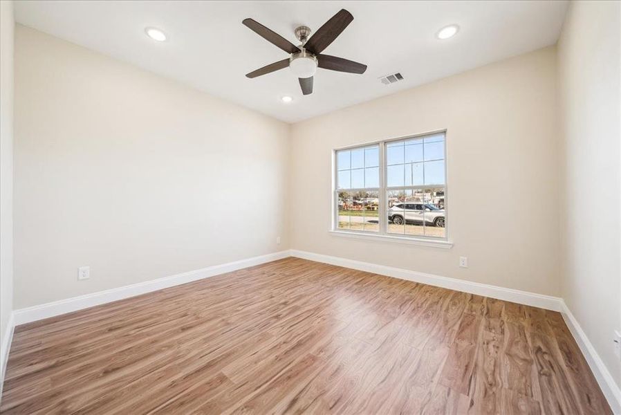 Unfurnished room with ceiling fan and light hardwood / wood-style floors