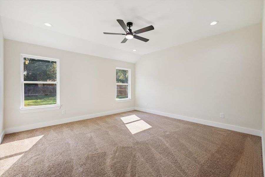 Empty room featuring carpet floors, recessed lighting, lofted ceiling, and a ceiling fan