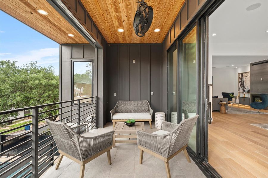 This property features a balcony with a wood plank ceiling and recessed lighting, offering an open-air extension of the interior