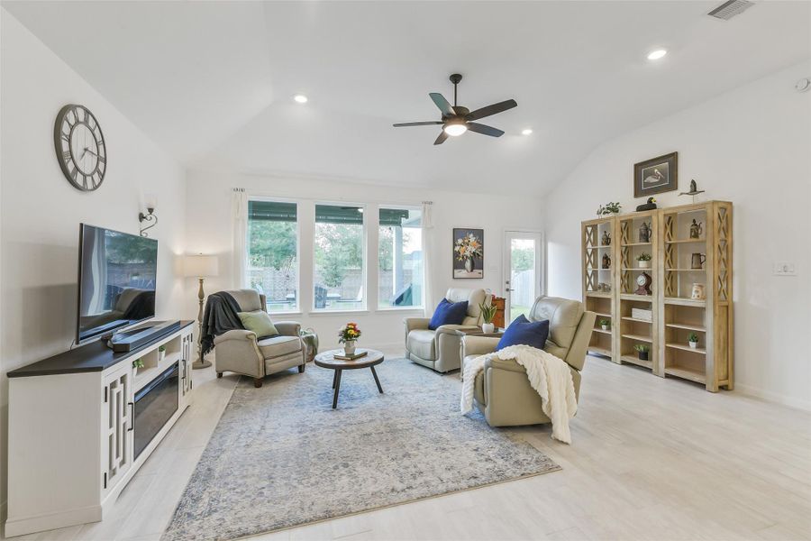 The spacious family room boasts a wall of windows to bring plenty of natural light to this beautiful space! The windows look out onto the extended back patio.