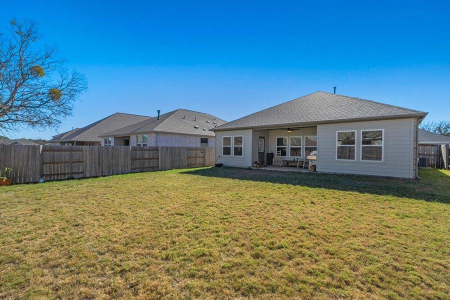 Back of property with a patio, a ceiling fan, and a fenced backyard