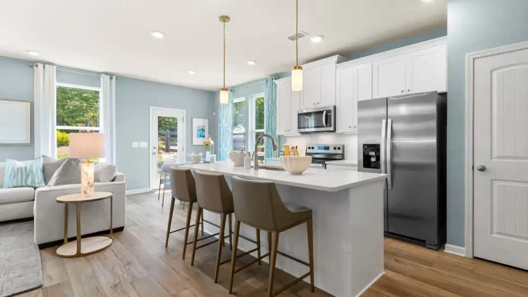 Modern kitchen in new construction townhome with large island, quartz countertops, and stainless appliances. Modern kitchen in new construction townhome with large island, quartz countertops, and stainless appliances.