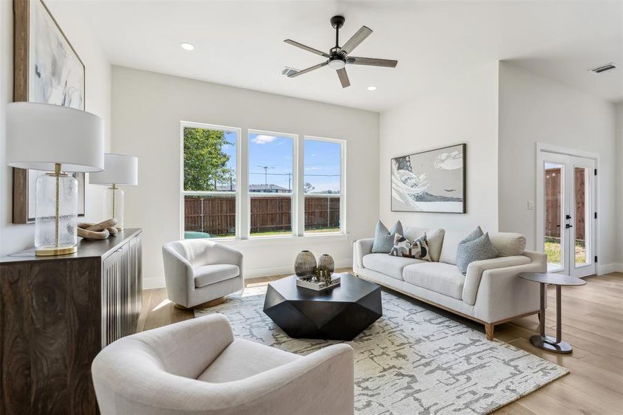 Living room with ceiling fan, light hardwood / wood-style flooring, french doors, and a healthy amount of sunlight