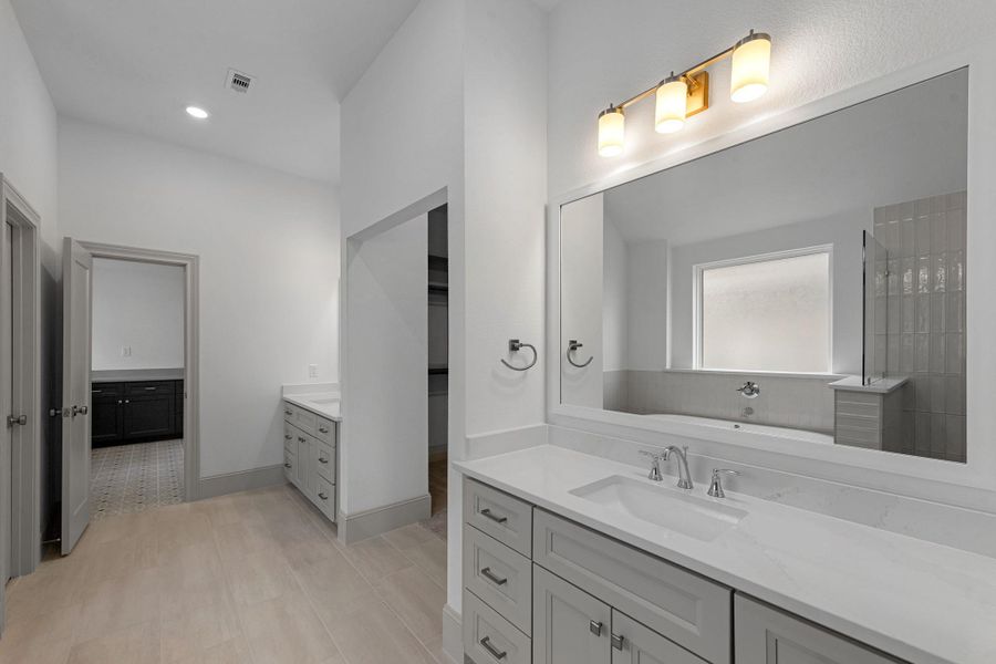 Accent tile surrounds the standing soaking tub and walk-in shower in the primary bathroom. Accent tile surrounds the standing soaking tub and walk-in shower in the primary bathroom.