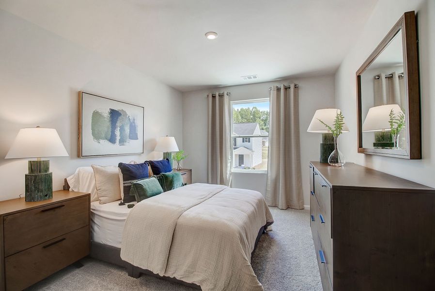 A bedroom with a large mirror.