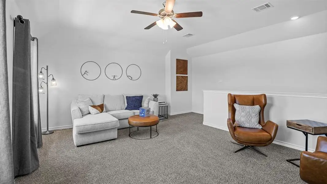 Living area featuring carpet, a ceiling fan, and lofted ceiling