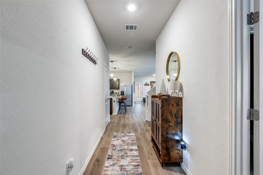 Hallway with light wood finished floors and a textured wall Hallway with light wood finished floors and a textured wall