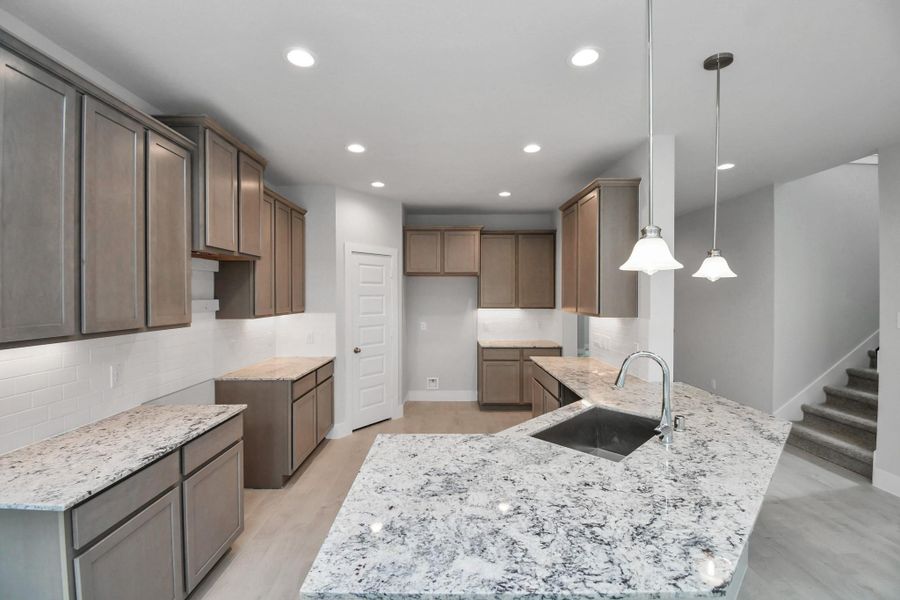 The open concept effortlessly connects the kitchen to the expansive family room, forming a perfect hub for gatherings. This seamless flow creates an inviting space where cooking and socializing come together harmoniously. Sample photo of completed home with similar floor plan. Actual colors and selections may vary. The open concept effortlessly connects the kitchen to the expansive family room, forming a perfect hub for gatherings. This seamless flow creates an inviting space where cooking and socializing come together harmoniously. Sample photo of completed home with similar floor plan. Actual colors and selections may vary.