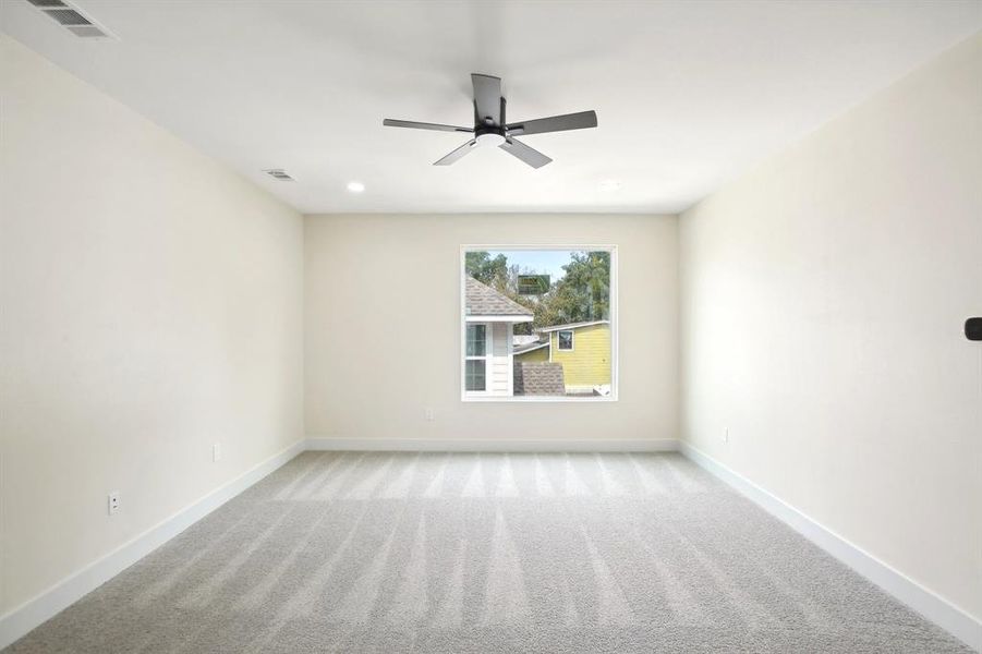 Carpeted spare room with ceiling fan