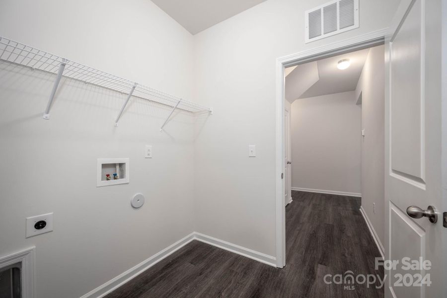 Laundry room with access to hall and primary closet