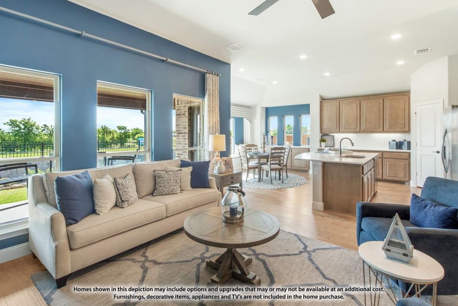 Open-concept living room with blue accent wall, flowing into dining area and kitchen with island. Open-concept living room with blue accent wall, flowing into dining area and kitchen with island.