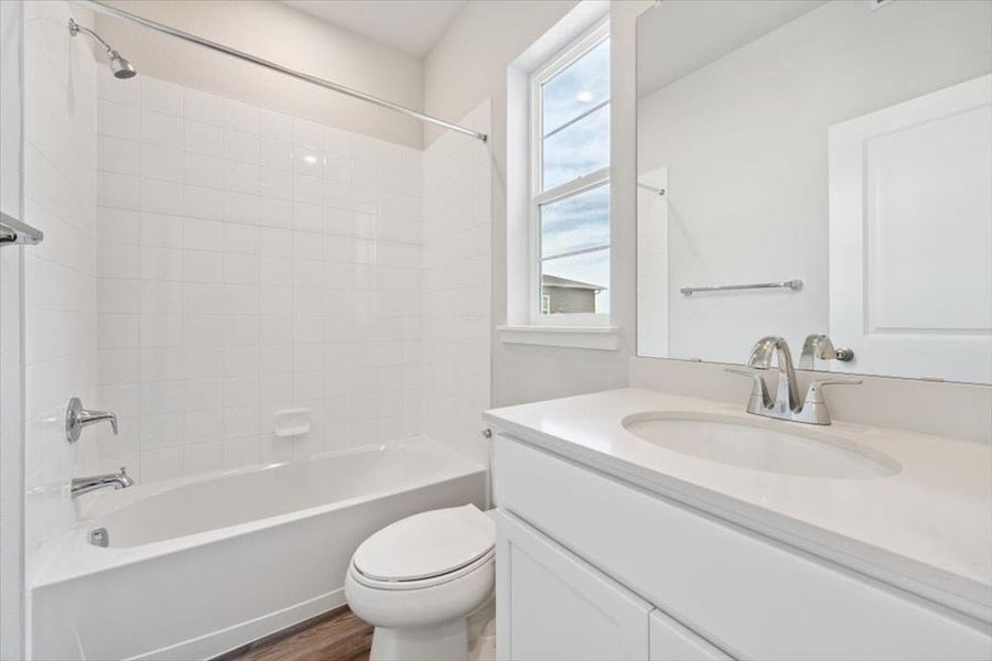 A bathroom with a tub sink and toilet. A bathroom with a tub sink and toilet.