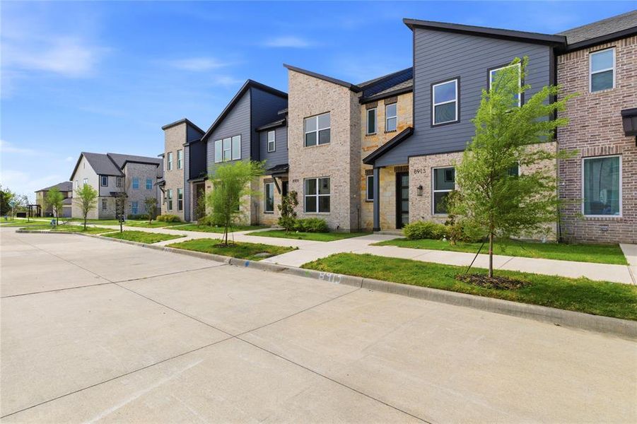 View of front facade with a residential view, brick siding, and a front yard