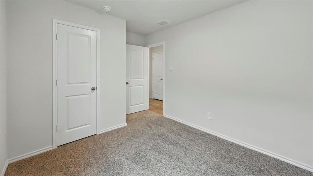 This room features soft carpet flooring, white walls, and white trim