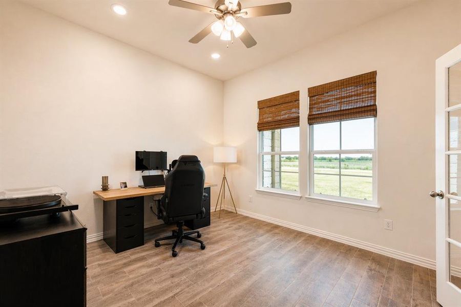 Room featuring wood-finish flooring, two large windows, recessed lighting, a ceiling fan, and French doors