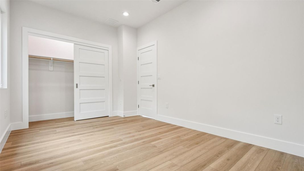 Unfurnished bedroom with a closet, light wood-style floors, and recessed lighting Unfurnished bedroom with a closet, light wood-style floors, and recessed lighting