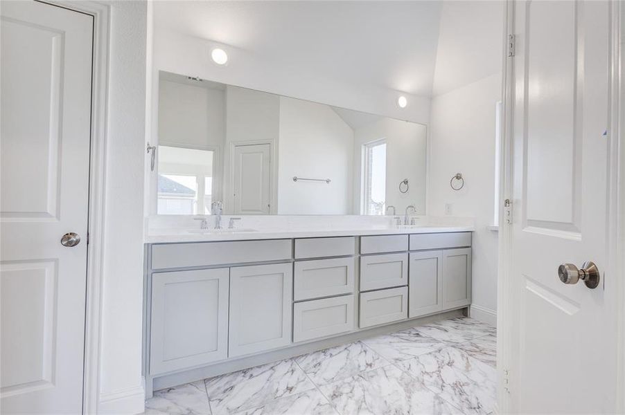 Bathroom featuring vanity and lofted ceiling