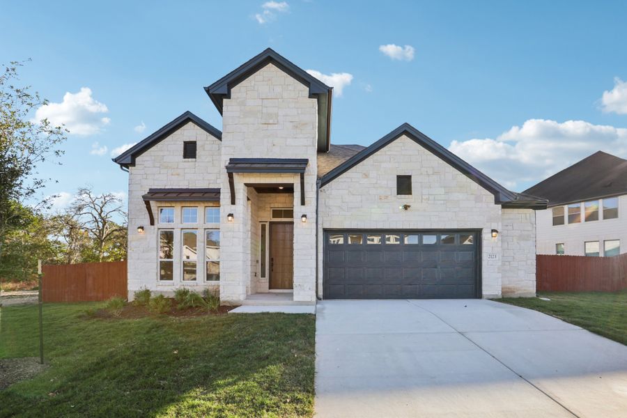 Front exterior of a new home in Sauls Ranch, Round Rock, TX, highlighting curb appeal (Image 1).