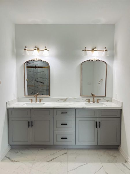 Bathroom featuring marble finish floor, baseboards, and a sink Bathroom featuring marble finish floor, baseboards, and a sink