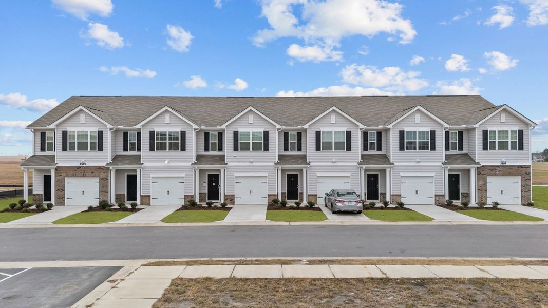 Front exterior of a new home in The Townes at Ridgewood Farms, Winterville, NC, highlighting curb appeal (Image 17). Front exterior of a new home in The Townes at Ridgewood Farms, Winterville, NC, highlighting curb appeal (Image 17).