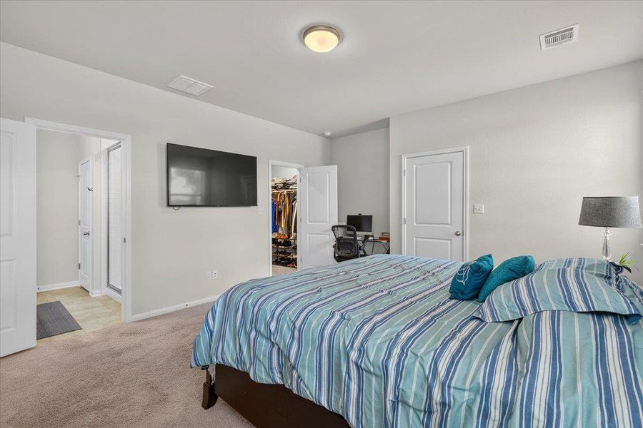 Wall-to-wall carpeting and smooth plaster walls define this comfortable bedroom suite.