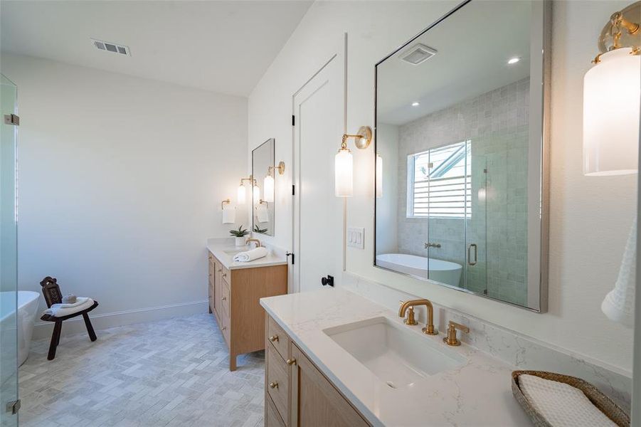 Bathroom featuring herringbone floors vanity and shower with separate bathtub