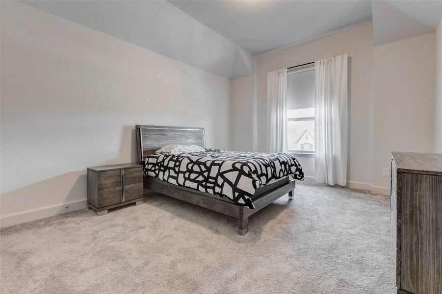 This bedroom features a cozy, minimalist design with plush carpeting The large window allows natural light to brighten the space, complemented by neutral walls and ceiling. This bedroom features a cozy, minimalist design with plush carpeting The large window allows natural light to brighten the space, complemented by neutral walls and ceiling.