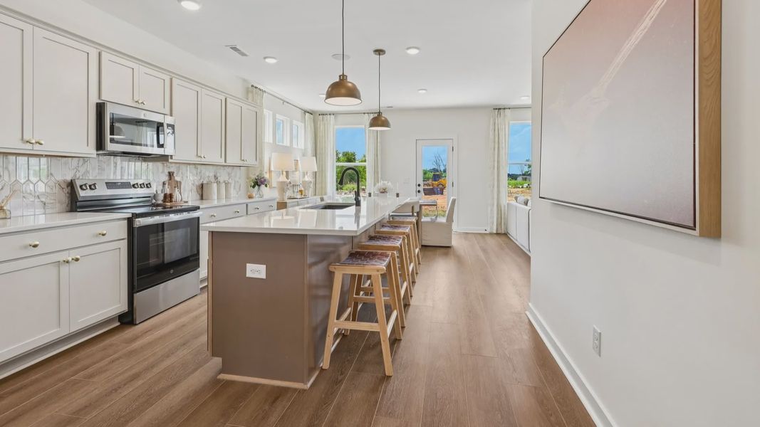 Kitchen with tile backsplash, pendant lighting, and quartz countertops