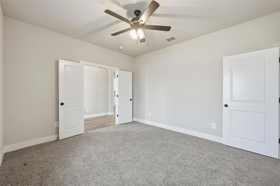 Unfurnished bedroom featuring carpet floors and ceiling fan