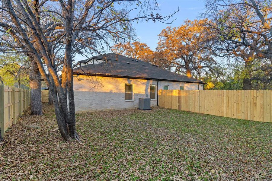 Back of property featuring a lawn and central AC unit