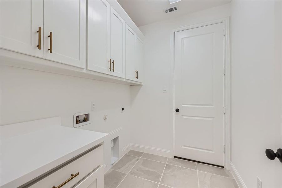 Laundry area featuring hookup for a washing machine, cabinets, gas dryer hookup, and hookup for an electric dryer