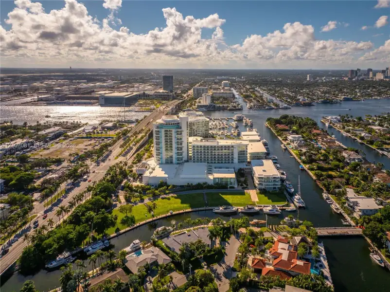 Aerial perspective featuring a high-rise residential structure, deep-water canal access, private boat slips, extensive waterfront, and proximity to coastal waterways Aerial perspective featuring a high-rise residential structure, deep-water canal access, private boat slips, extensive waterfront, and proximity to coastal waterways