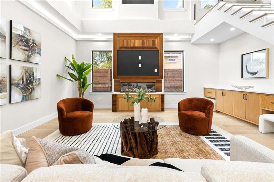 Living room with a towering ceiling and light wood-type flooring