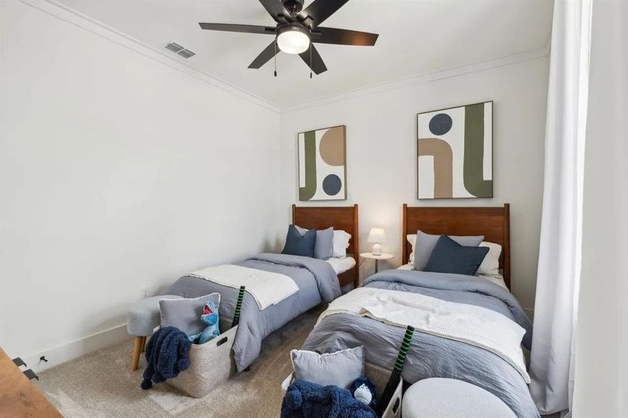 Carpeted bedroom featuring ornamental molding and a ceiling fan