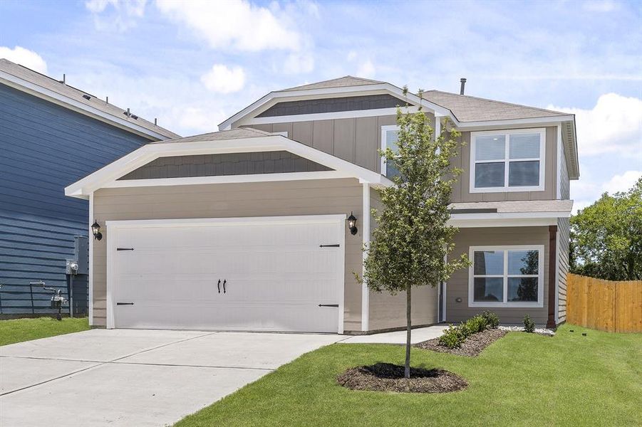 View of front of house featuring a garage and a front lawn