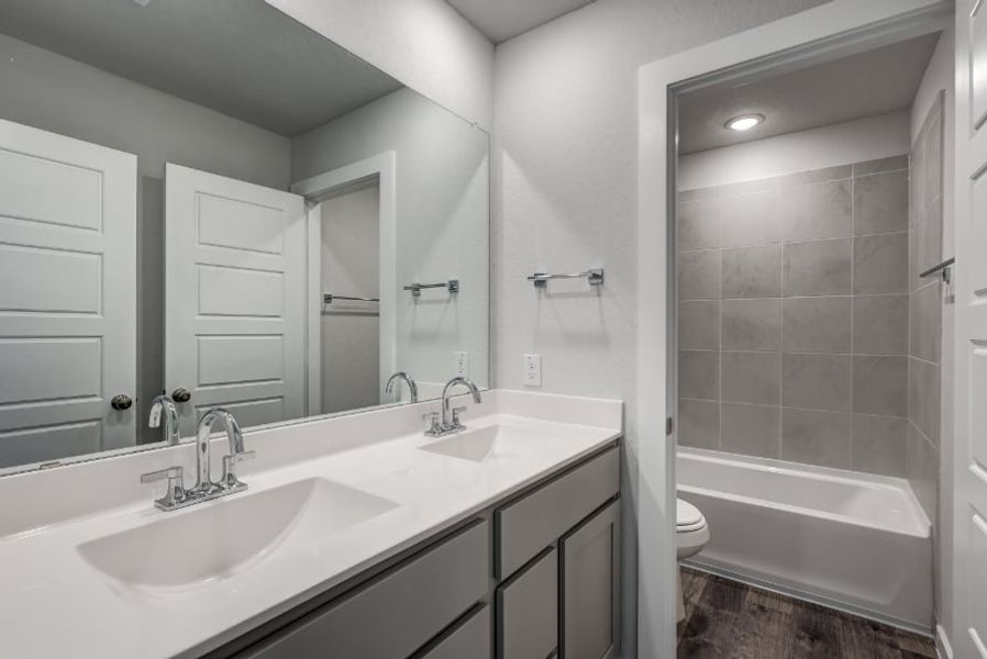A bathroom with a tub sink and toilet. A bathroom with a tub sink and toilet.